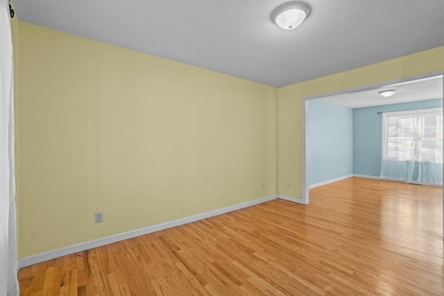 spare room with light wood-type flooring and baseboards