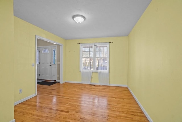empty room featuring wood finished floors and baseboards