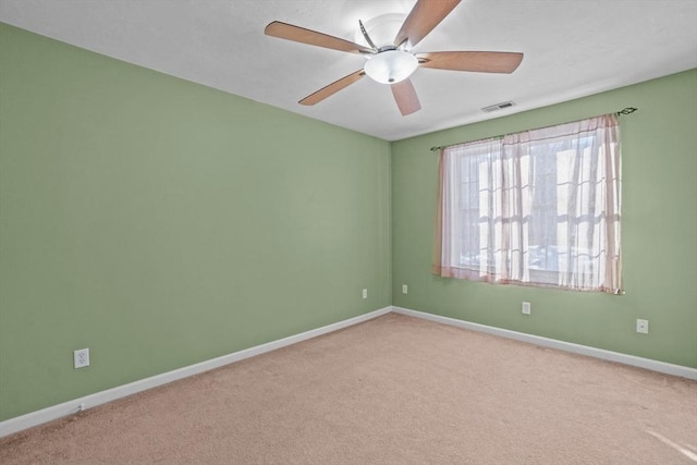 spare room featuring carpet floors, ceiling fan, and baseboards