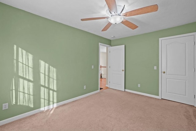 unfurnished bedroom featuring carpet flooring, baseboards, and a ceiling fan