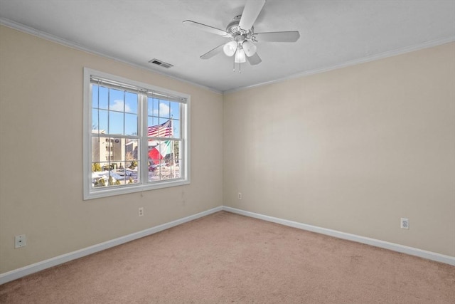 unfurnished room featuring light colored carpet, baseboards, crown molding, and a ceiling fan