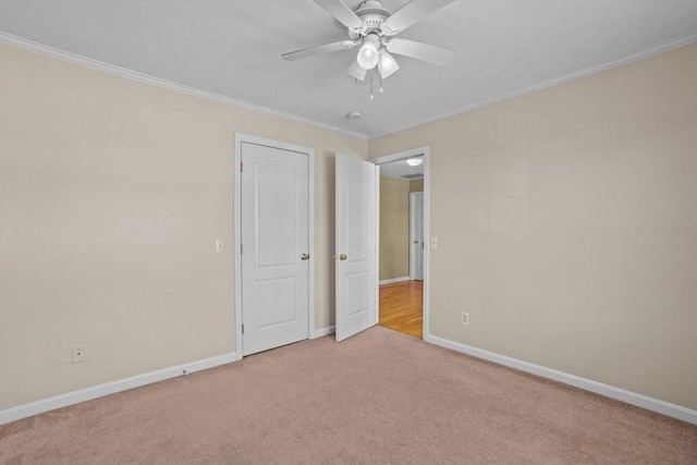 unfurnished bedroom with light carpet, crown molding, baseboards, and a ceiling fan