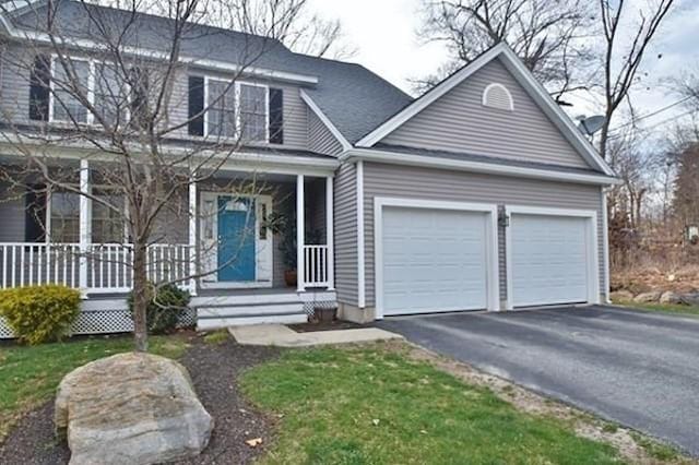 view of front of property featuring a garage, asphalt driveway, and a porch