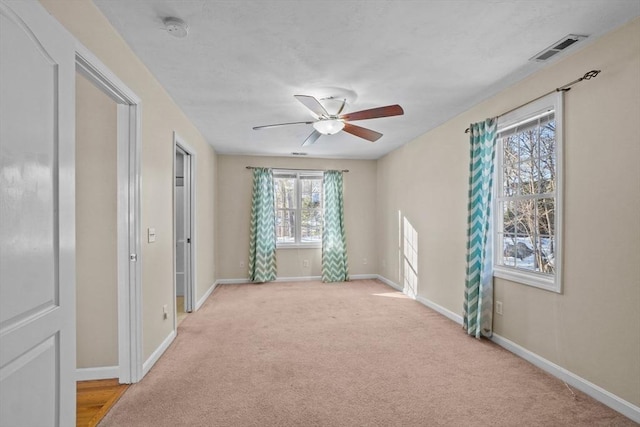 unfurnished bedroom featuring baseboards, light colored carpet, and ceiling fan