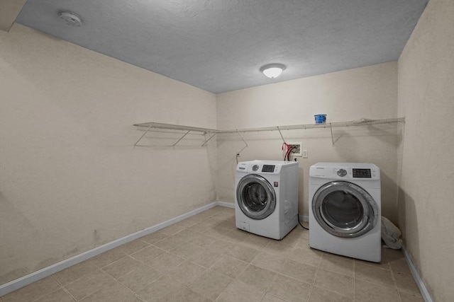 laundry room featuring washing machine and dryer and baseboards