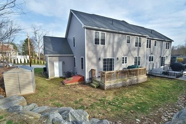 rear view of property with a deck, a yard, and central AC unit