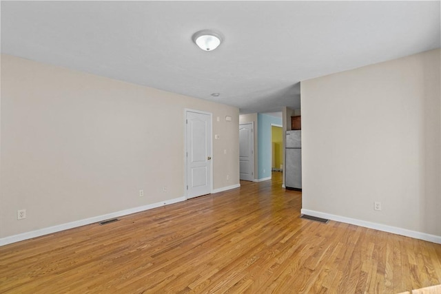 empty room featuring baseboards and light wood-type flooring
