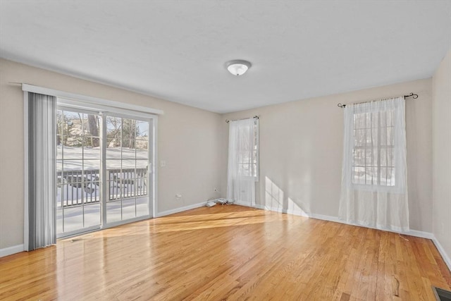 unfurnished room with baseboards and light wood finished floors