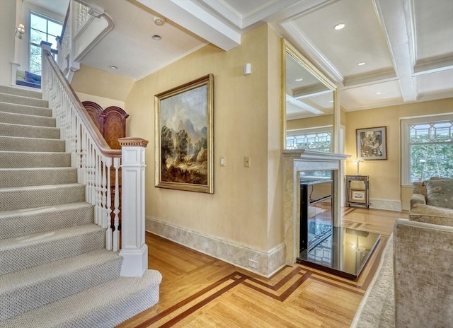 10 Sheffield Rd, Winchester, MA 01890 - stairway with wood finished floors, baseboards, beamed ceiling, crown molding, and a glass covered fireplace