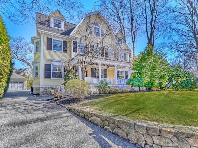 10 Sheffield Rd, Winchester, MA 01890 - view of front of house featuring covered porch, an outbuilding, a front yard, and a garage
