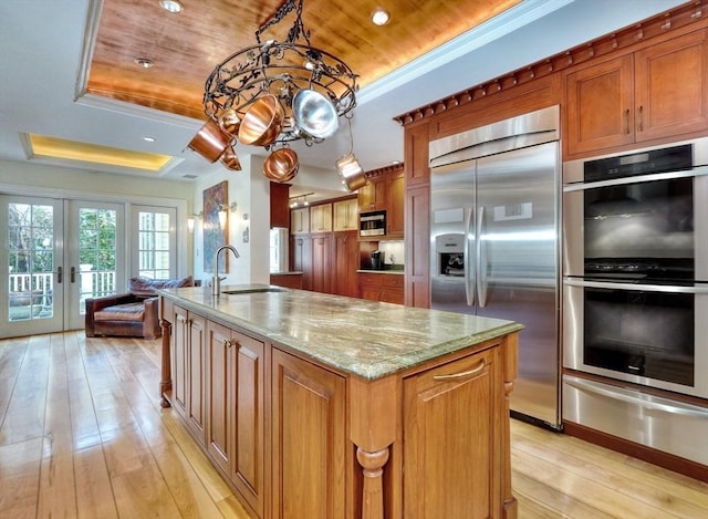 10 Sheffield Rd, Winchester, MA 01890 - kitchen featuring appliances with stainless steel finishes, a warming drawer, a tray ceiling, a sink, and light stone counters