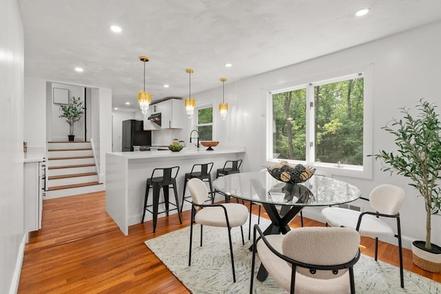 379 Dedham Ave, Needham, MA 02492 - dining room featuring recessed lighting, light wood finished floors, baseboards, and stairs