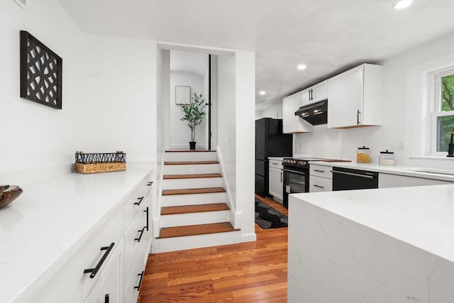 379 Dedham Ave, Needham, MA 02492 - kitchen with black appliances, recessed lighting, light wood-type flooring, white cabinets, and a sink
