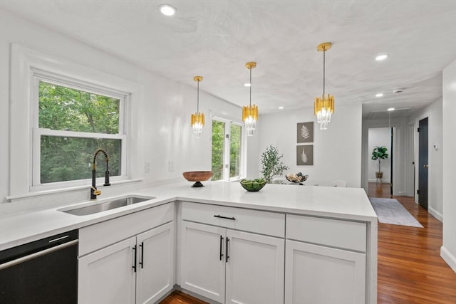 379 Dedham Ave, Needham, MA 02492 - kitchen with a sink, black dishwasher, a peninsula, a chandelier, and decorative light fixtures