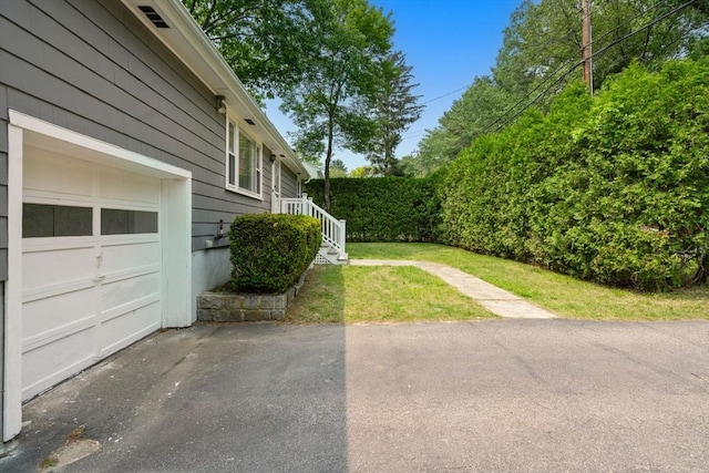 379 Dedham Ave, Needham, MA 02492 - view of green lawn featuring a garage and asphalt driveway