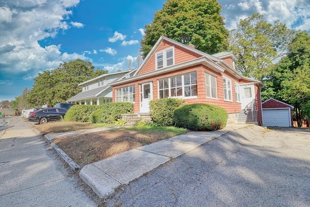 view of front of house with driveway, an outdoor structure, and a detached garage