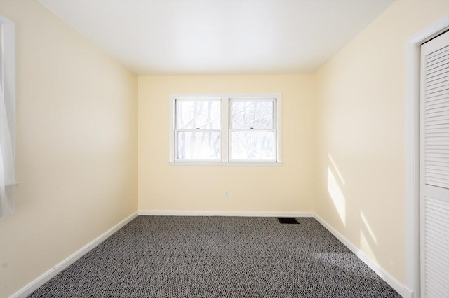 carpeted empty room featuring visible vents and baseboards