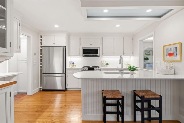 28 Pleasant View Rd, Arlington, MA 02476 - kitchen featuring appliances with stainless steel finishes, a breakfast bar, white cabinetry, light countertops, and recessed lighting