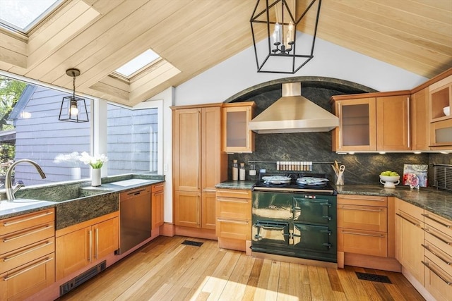 kitchen featuring wall chimney exhaust hood, stainless steel dishwasher, lofted ceiling with skylight, pendant lighting, and light wood-type flooring