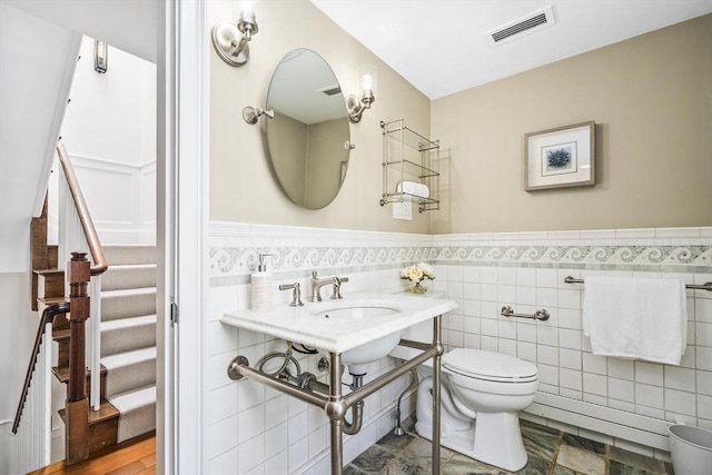 bathroom with tile walls and toilet