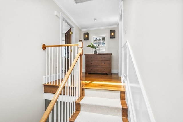 staircase with hardwood / wood-style floors and crown molding