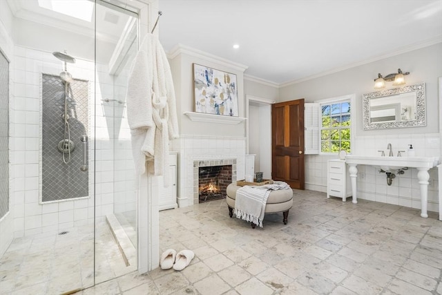 bathroom with a fireplace, ornamental molding, tile walls, and tiled shower