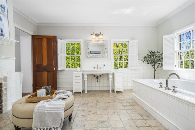 bathroom with tiled bath, crown molding, tile walls, and a healthy amount of sunlight