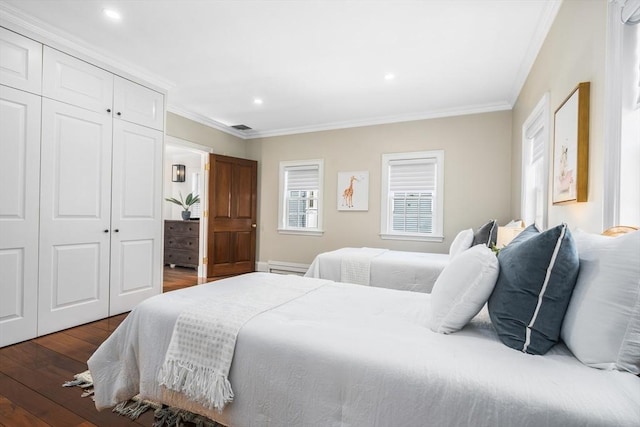 bedroom with crown molding, a closet, and dark wood-type flooring