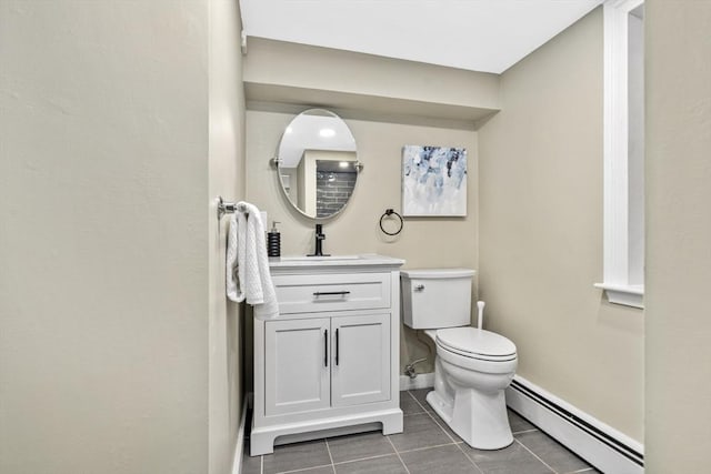 bathroom with toilet, vanity, a baseboard radiator, and tile patterned floors