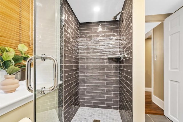 bathroom featuring hardwood / wood-style floors and a shower with shower door