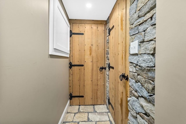 hallway featuring wooden walls