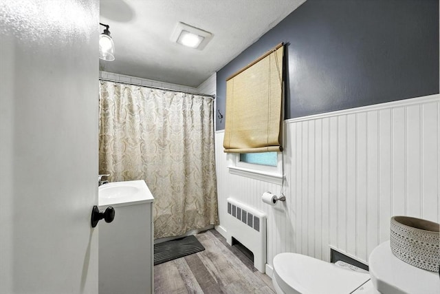 149 N Main St, South Hadley, MA 01075 - full bathroom with radiator heating unit, wood finished floors, vanity, wainscoting, and a shower with curtain