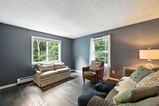 149 N Main St, South Hadley, MA 01075 - living area featuring baseboard heating, wood finished floors, and a textured ceiling