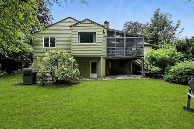 149 N Main St, South Hadley, MA 01075 - rear view of house featuring a sunroom, a patio, a chimney, a yard, and stairs