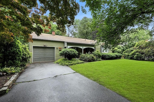149 N Main St, South Hadley, MA 01075 - single story home featuring asphalt driveway, a garage, a front lawn, and a chimney