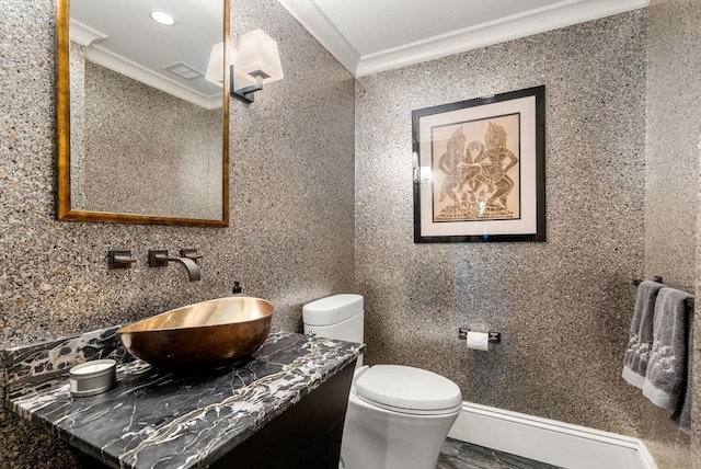 bathroom with ornamental molding, vanity, and toilet