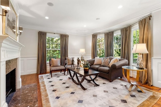 living area featuring a healthy amount of sunlight, a fireplace, ornamental molding, and a decorative wall