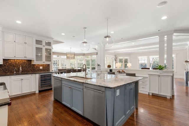 kitchen with a center island with sink, gray cabinetry, glass insert cabinets, white cabinets, and beverage cooler