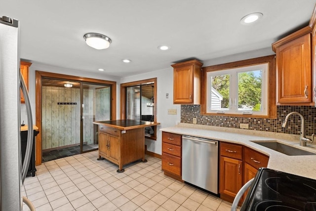 kitchen with baseboards, tasteful backsplash, appliances with stainless steel finishes, and a sink