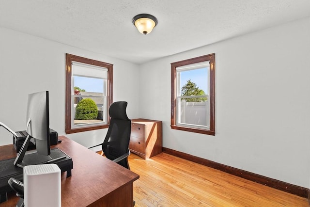 office area featuring baseboards and light wood finished floors