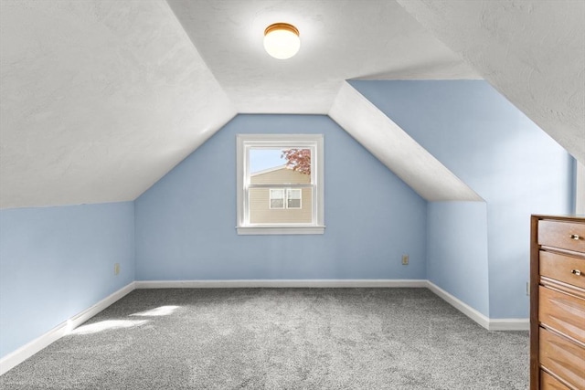 additional living space with carpet flooring, baseboards, and lofted ceiling