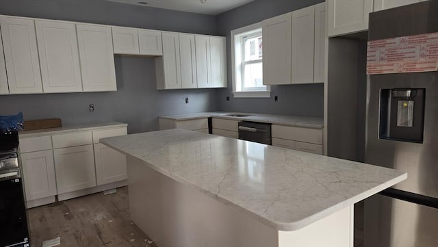 kitchen with light stone countertops, a kitchen island, white cabinetry, and stainless steel fridge with ice dispenser