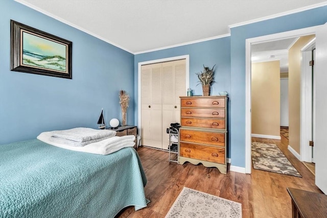 bedroom with hardwood / wood-style flooring, ornamental molding, and a closet