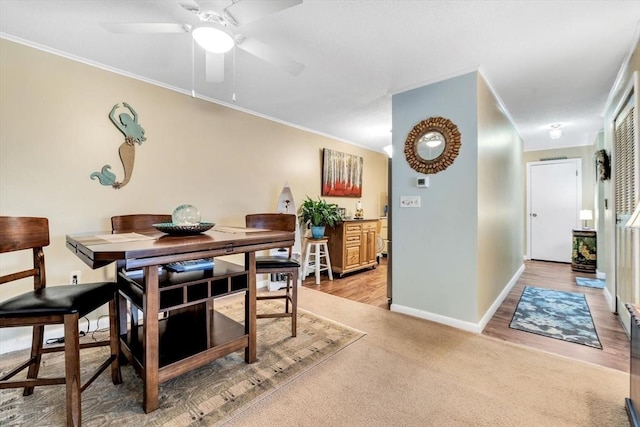 carpeted dining area featuring crown molding and ceiling fan