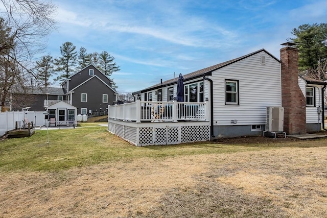 rear view of property featuring a wooden deck and a chimney