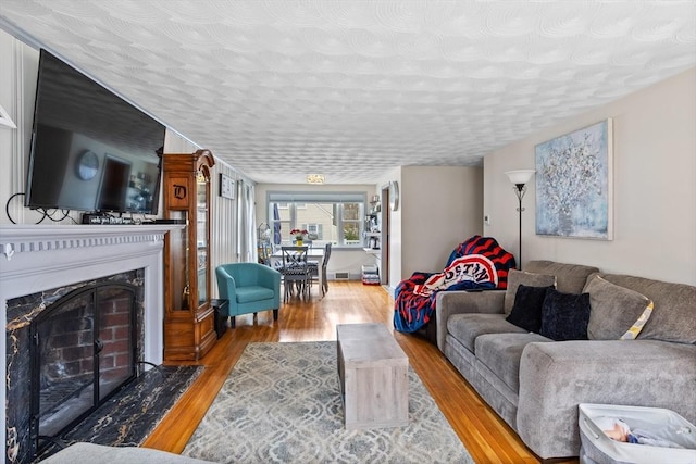 living area featuring wood finished floors and a fireplace with flush hearth