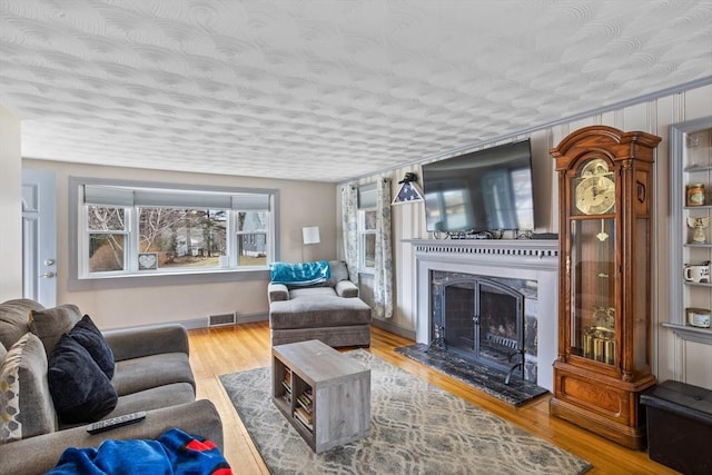 living area with a high end fireplace and wood finished floors