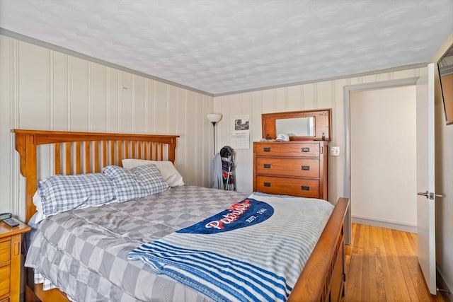 bedroom with hardwood / wood-style floors, baseboards, and crown molding