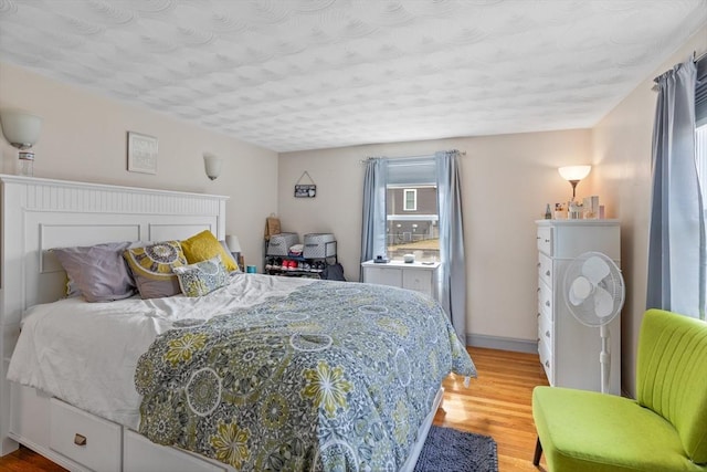 bedroom featuring light wood-style floors and baseboards