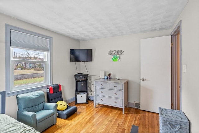 living area with light wood-style flooring and baseboards